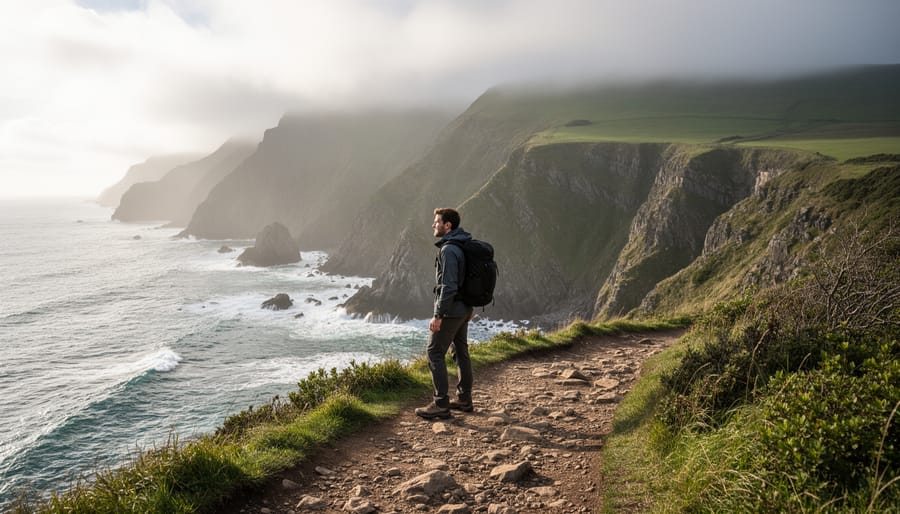 A hiker on the Skyline Trail ridge with Atlantic coastal cliffs in the distance